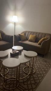 a living room with two tables and a couch at شقه مفروشة فاخره بدخول ذاتي in Al Kharj