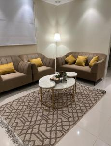 a living room with two couches and a table at شقه مفروشة فاخره بدخول ذاتي in Al Kharj