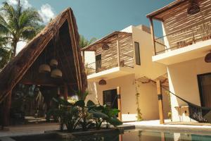 une maison avec une piscine en face de celle-ci dans l'établissement Nikau Hotel El Cuyo - Adults Only, à El Cuyo