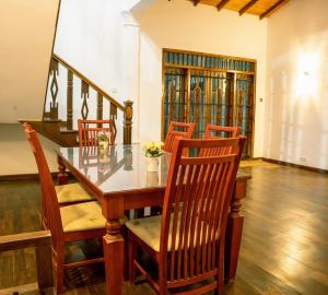 comedor con mesa de madera y sillas en Elegant Riverside Villa, en Dematapelessa