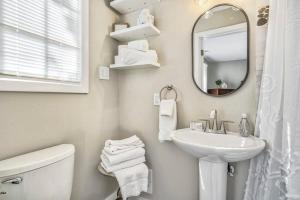 La salle de bains blanche est pourvue d'un lavabo et d'un miroir. dans l'établissement 2BR Pikes Peak View and Nestled in the Trees, à Woodland Park