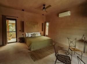 a bedroom with a bed and a fan at Nikau Hotel El Cuyo - Adults Only in El Cuyo