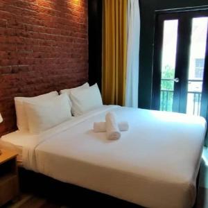 a white bed with two towels on top of it at Seeds Hotel Puchong Koi in Puchong