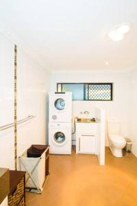 a bathroom with a washing machine and a toilet at Moorings - Beach house with pool in beautiful 1770 in Seventeen Seventy