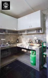 a kitchen with white cabinets and a green trash can at Deleted 6 in Calayo