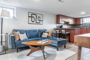 uma sala de estar com um sofá azul e uma mesa em COZY 2-BEDROOM BASEMENT SUITE em Mississauga