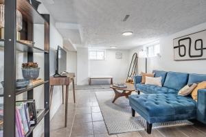 a living room with a blue couch and a table at COZY 2-BEDROOM BASEMENT SUITE in Mississauga