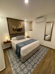 ein Schlafzimmer mit einem großen Bett und einem Teppich in der Unterkunft Hotel Tierra Marina Centro Historico in Mazatlán