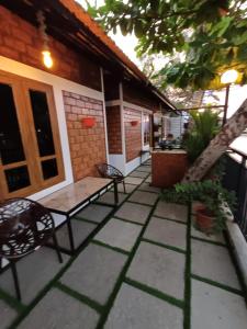 a patio with a table and chairs on a house at East West Beach Resorts in Varkala
