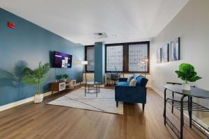 een woonkamer met een blauwe bank en een tafel bij 1B1B Upscale Charm Valet Gym Lounge Roku in Pittsburgh