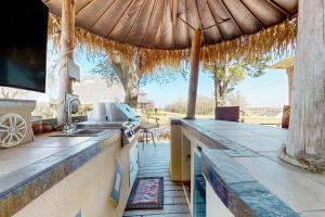 an outdoor kitchen with a counter and an umbrella at Sunset Cove in Bridgeport