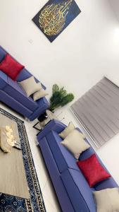 un soggiorno con divano blu e cuscini rossi di Best Residence a Nouakchott