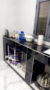 a kitchen with a black counter top with dishes at Best Residence in Nouakchott