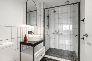 La salle de bains est pourvue d'une douche, d'un lavabo et d'un miroir. dans l'établissement Modern, Industrial Hideaway, à Melbourne