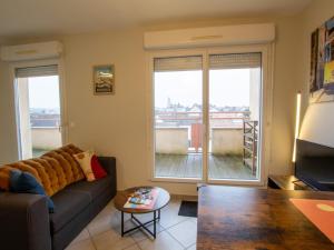 a living room with a couch and a balcony at Appartement Périgueux, 2 pièces, 2 personnes - FR-1-616-352 in Périgueux