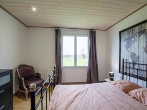 ein Schlafzimmer mit einem Bett, einem Stuhl und einem Fenster in der Unterkunft Gîte Saint-Aulaye-Puymangou, 2 pièces, 2 personnes - FR-1-616-358 