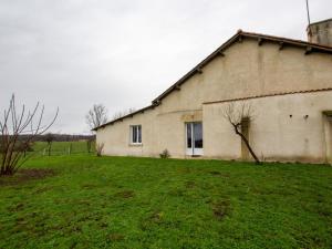ein altes Gebäude mit einem Grasfeld daneben in der Unterkunft Gîte Saint-Aulaye-Puymangou, 2 pièces, 2 personnes - FR-1-616-358 