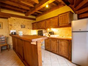 PézulsにあるCharmante maison 4 pers avec piscine privative et grand terrain, proche sites touristiques du Périgord - FR-1-616-350の木製のキャビネットと白い冷蔵庫を備えたキッチン +2枚の写真