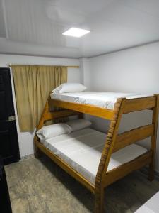 Ce dortoir comprend 2 lits superposés et une fenêtre. dans l'établissement Hotel Palmetto Beach Coveñas, à Coveñas