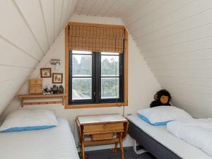 2 Betten in einem kleinen Zimmer mit Fenster in der Unterkunft Holiday home Fanø XX in Fanø