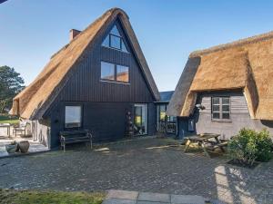 ein strohgedecktes Haus mit einem Picknicktisch davor in der Unterkunft Holiday home Fanø XX in Fanø