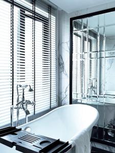 une baignoire blanche dans une salle de bains avec fenêtre dans l'établissement Glory Boutique Suites 清迈古城荣耀精品酒店, à Chiang Mai 47 autres photos