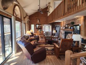 een woonkamer met lederen meubels en een trap bij Buckhorn Lodge in Maggie Valley