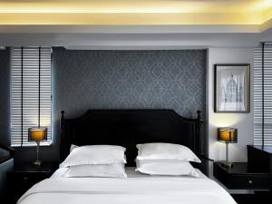 una camera con un grande letto con due lampade di Glory Boutique Suites 清迈古城荣耀精品酒店 a Chiang Mai