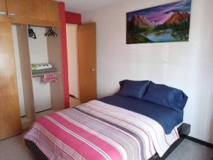 a bedroom with a bed and a painting on the wall at Casa Almendros in Mexico City
