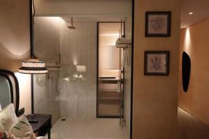 a bathroom with a shower with a glass door at L'amor Boutique Hotel Quy Nhơn in Quy Nhon