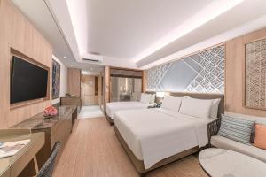 En eller flere senge i et værelse på Henann Premier Coast Resort