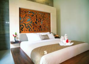 a bedroom with a bed with a painting on the wall at Villa Elsa Seaview in Temukus