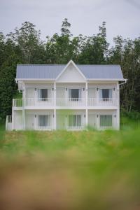 ein weißes Haus mit grauem Dach in der Unterkunft White Roses Cottage in Keningau