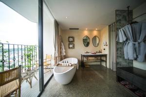 baño con bañera y balcón. en L'amor Boutique Hotel Quy Nhơn, en Quy Nhon