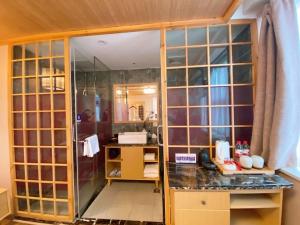 een badkamer met een douche en een glazen wand bij Fresh Hours Hotel - West Lake Qingchun in Hangzhou