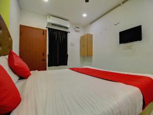 a bedroom with a large white bed with red pillows at OYO Flagship Ananda Inn in Madurai