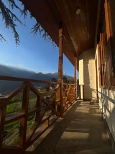 um alpendre de uma casa com vista para as montanhas em TSUKIMI Homestay, Naggar, Manali em Nagar