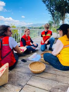 a group of people sitting on a deck in superhero costumes at Tám Trình Coffee Farm in Hoat