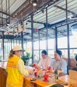 tres mujeres de pie en un mostrador en un restaurante en Tám Trình Coffee Farm, en Hoat