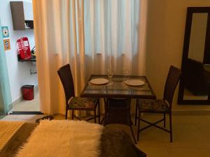 uma sala de jantar com uma mesa e cadeiras com copos de vinho em Recanto Nova Canaã em Conceição de Jacuípe