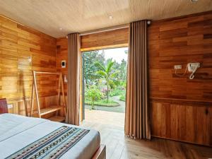 Schlafzimmer mit einem Bett und einer Glasschiebetür in der Unterkunft Trang An Four Seasons Retreat in Ninh Bình