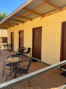 a deck with tables and chairs on a building at Bright Cabin Park in Bright
