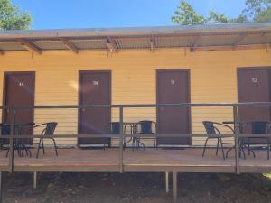 a deck with chairs and tables and a building at Bright Cabin Park in Bright