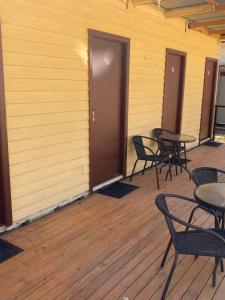a row of tables and chairs on a wooden deck at Bright Cabin Park in Bright