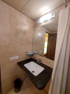 a bathroom with a sink and a mirror at Whispering Palms Hotel Jaipur in Jaipur