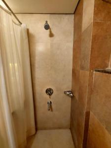 a bathroom with a shower with a shower curtain at Whispering Palms Hotel Jaipur in Jaipur