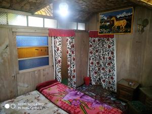 a small bedroom with a bed and a window at The Hotel "Shafeeq" Across jawahar bridge in Srinagar