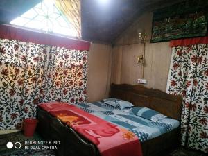 a bedroom with a bed in a room with curtains at The Hotel "Shafeeq" Across jawahar bridge in Srinagar