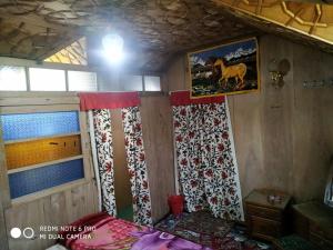 a bedroom with a bed with curtains and a window at The Hotel "Shafeeq" Across jawahar bridge in Srinagar