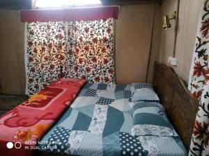 a bed with a quilt on it in a room at The Hotel "Shafeeq" Across jawahar bridge in Srinagar